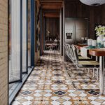 Moroccan geometric floor tiles with warm earthy patterns used in a contemporary dining space by Timex Ceramic