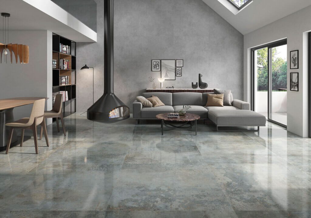 Rusty Moss patina porcelain floor tiles with weathered texture in a living and dining space
with fireplace.